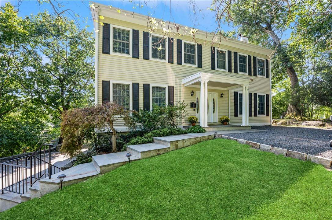 a front view of a house with a yard and trees