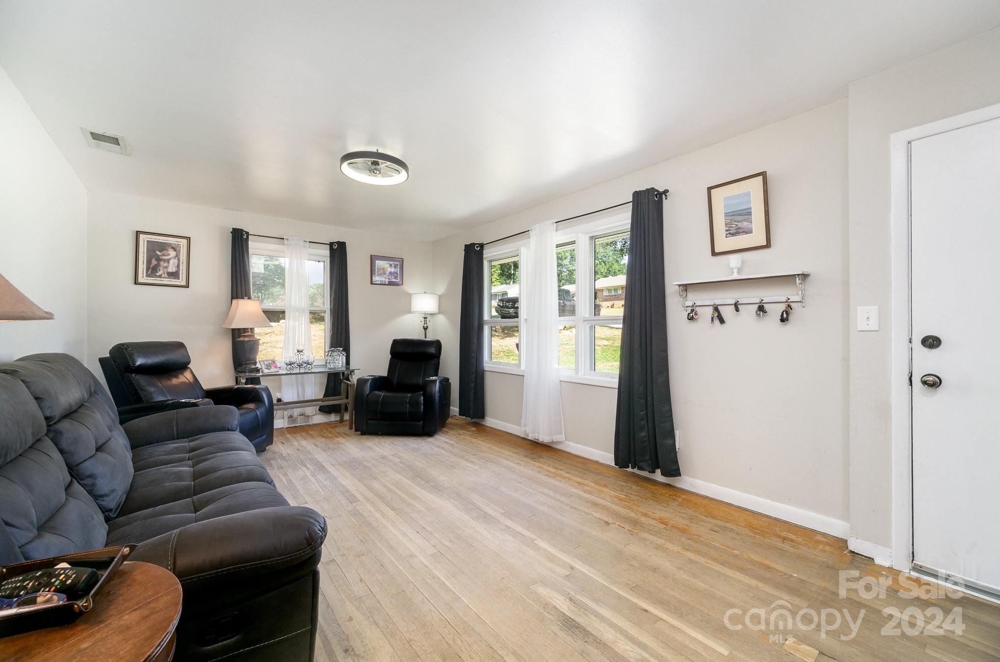 a living room with furniture and a wooden floor