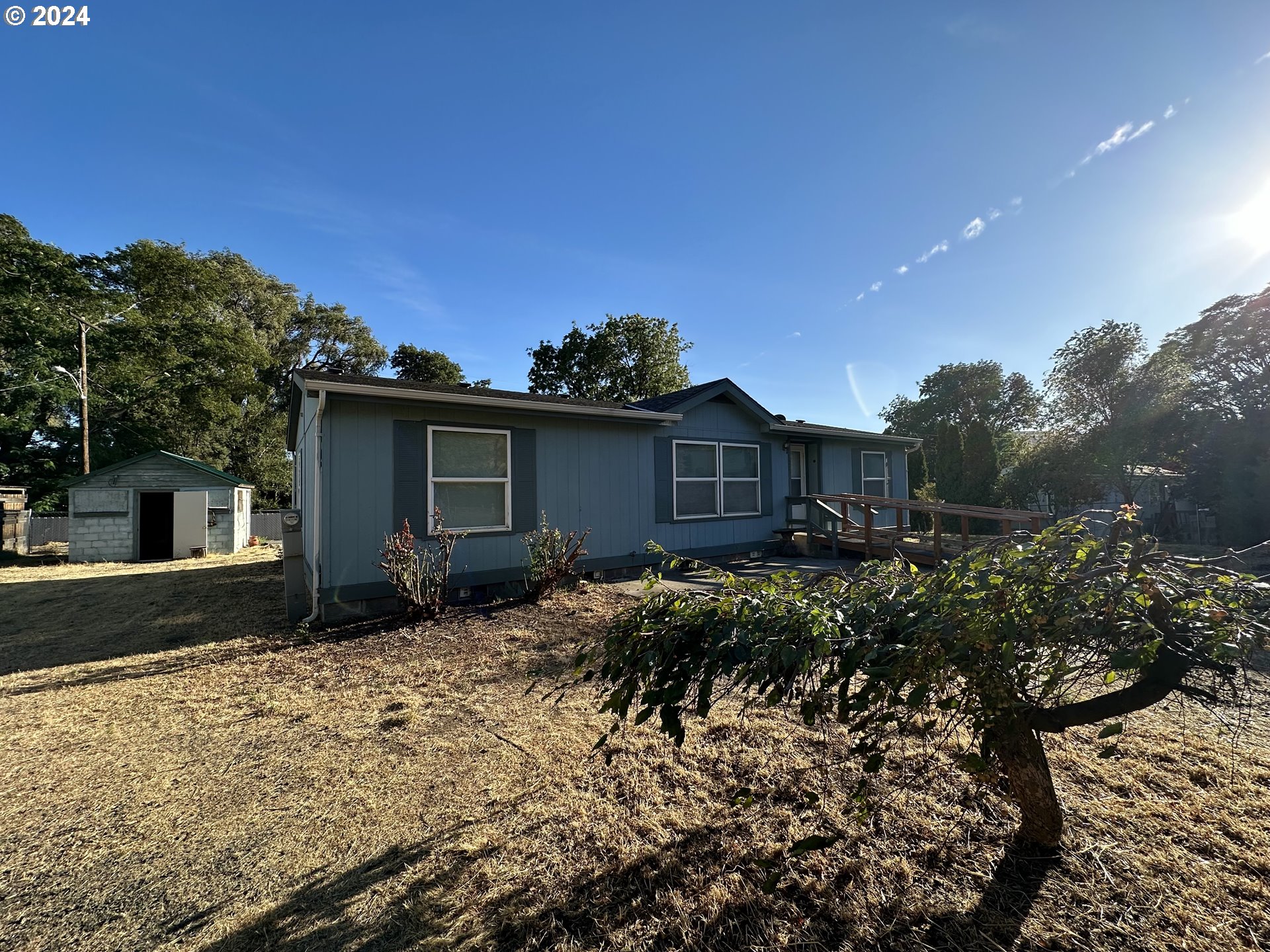 a front view of house with yard and trees around