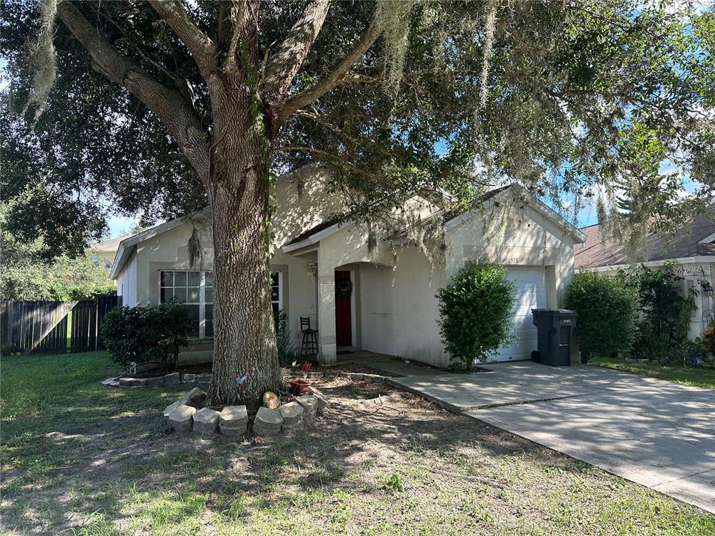 a front view of a house with a yard and trees