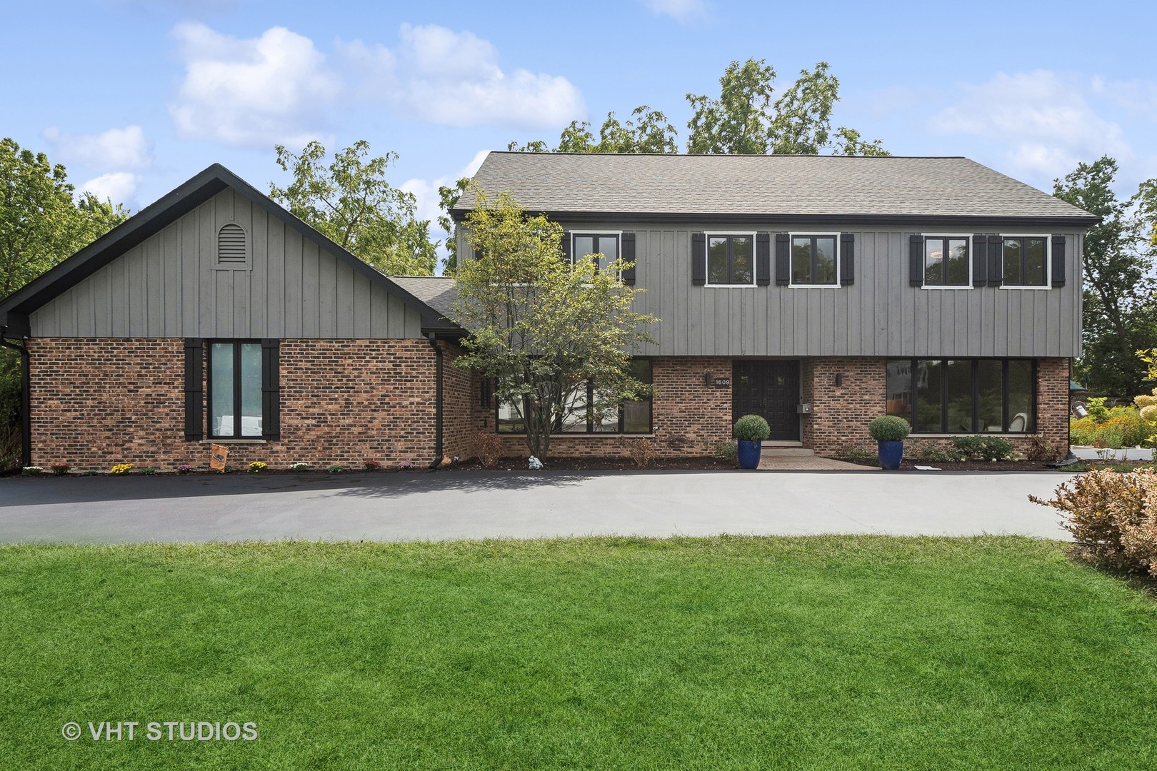 a front view of a house with a garden and yard