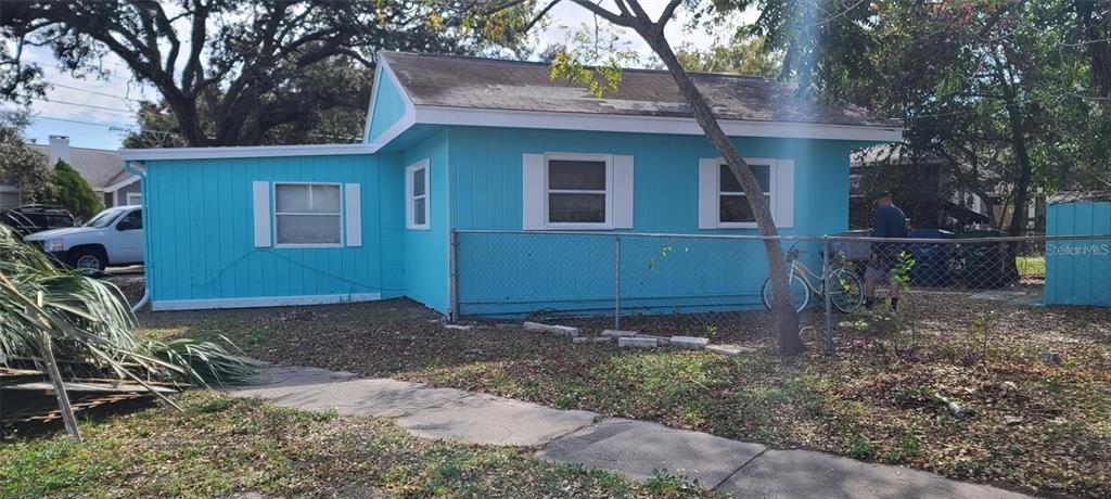 a view of a house with a yard and tree