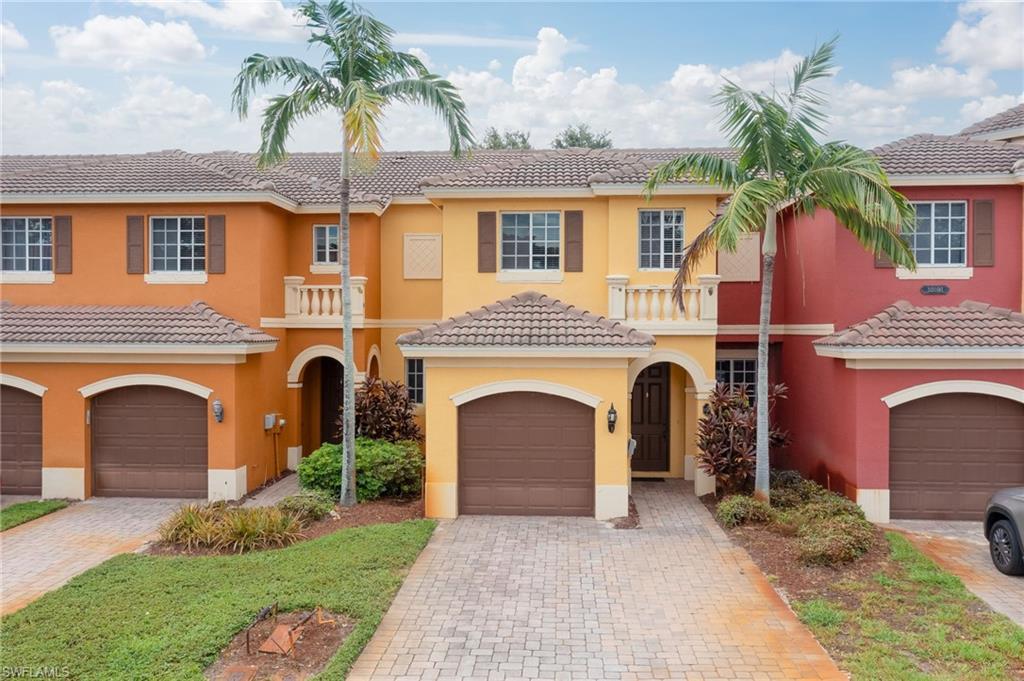 a front view of a house with yard and parking