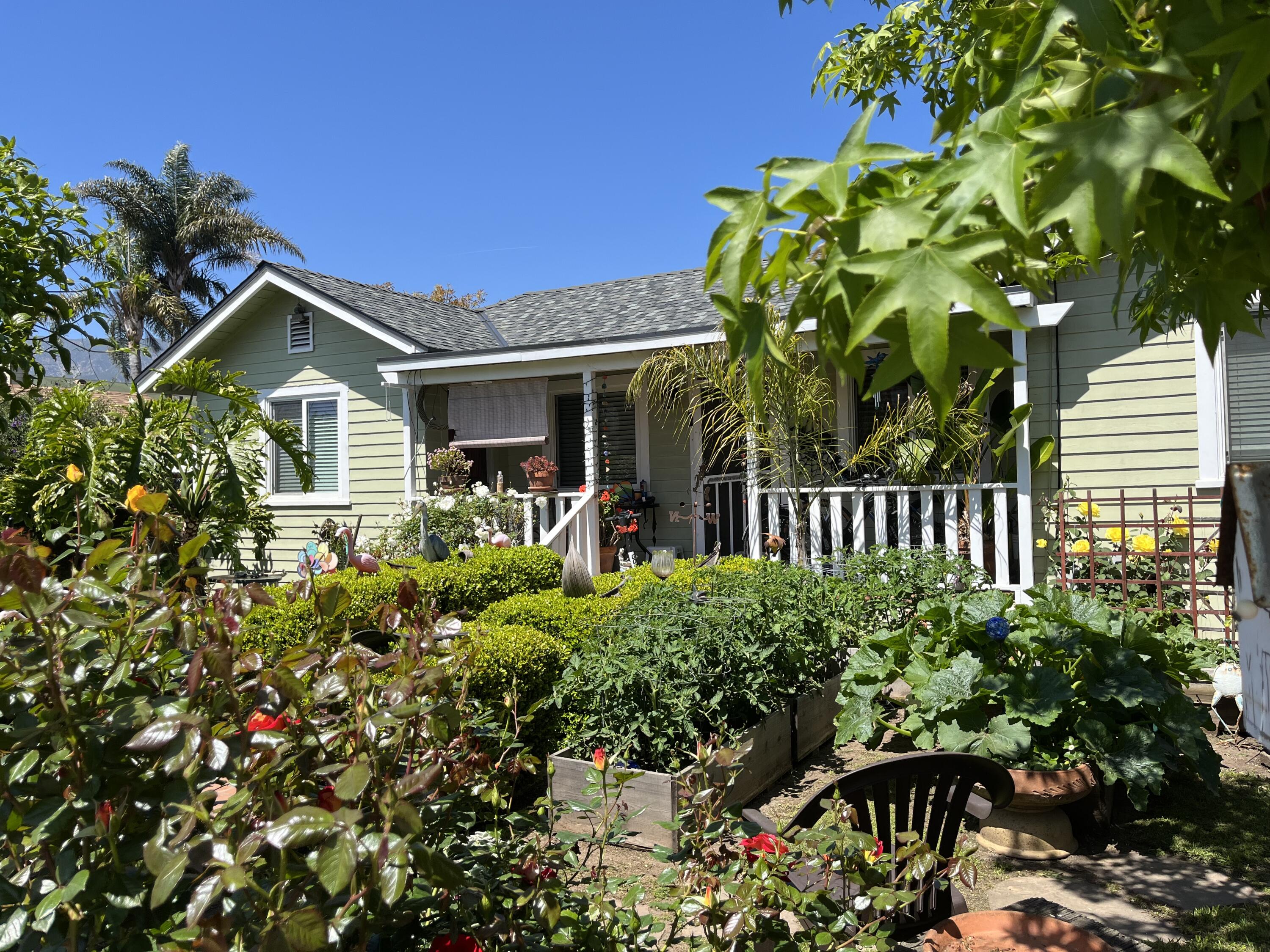 a front view of a house with a flower garden