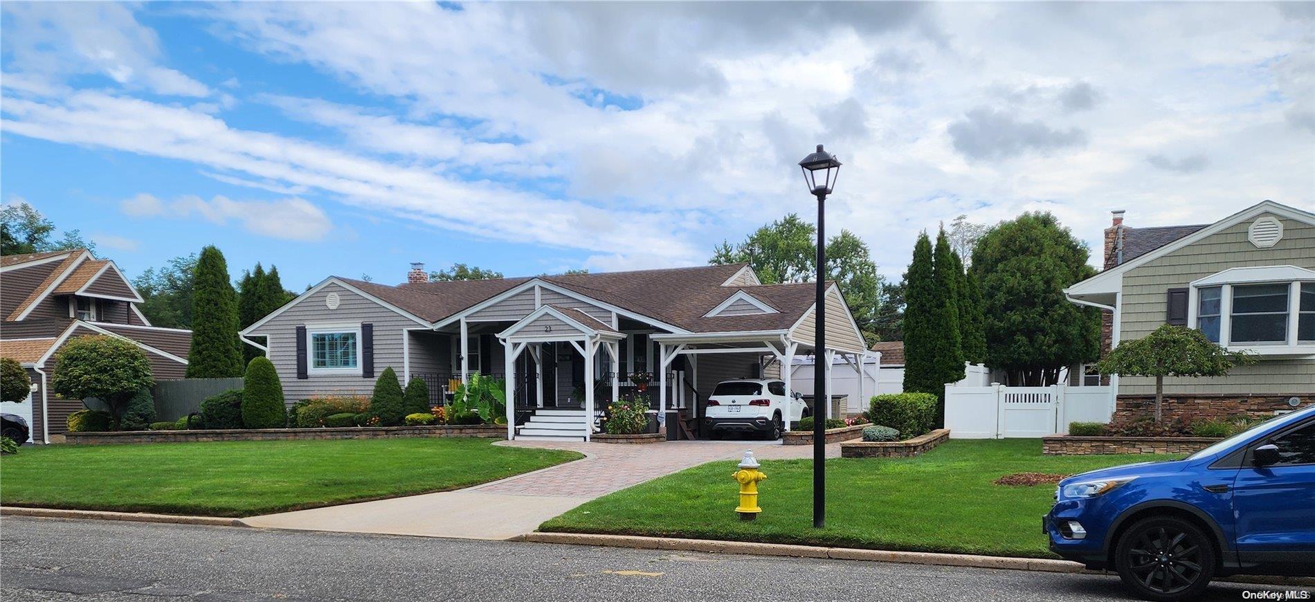 a front view of a house with a garden and trees