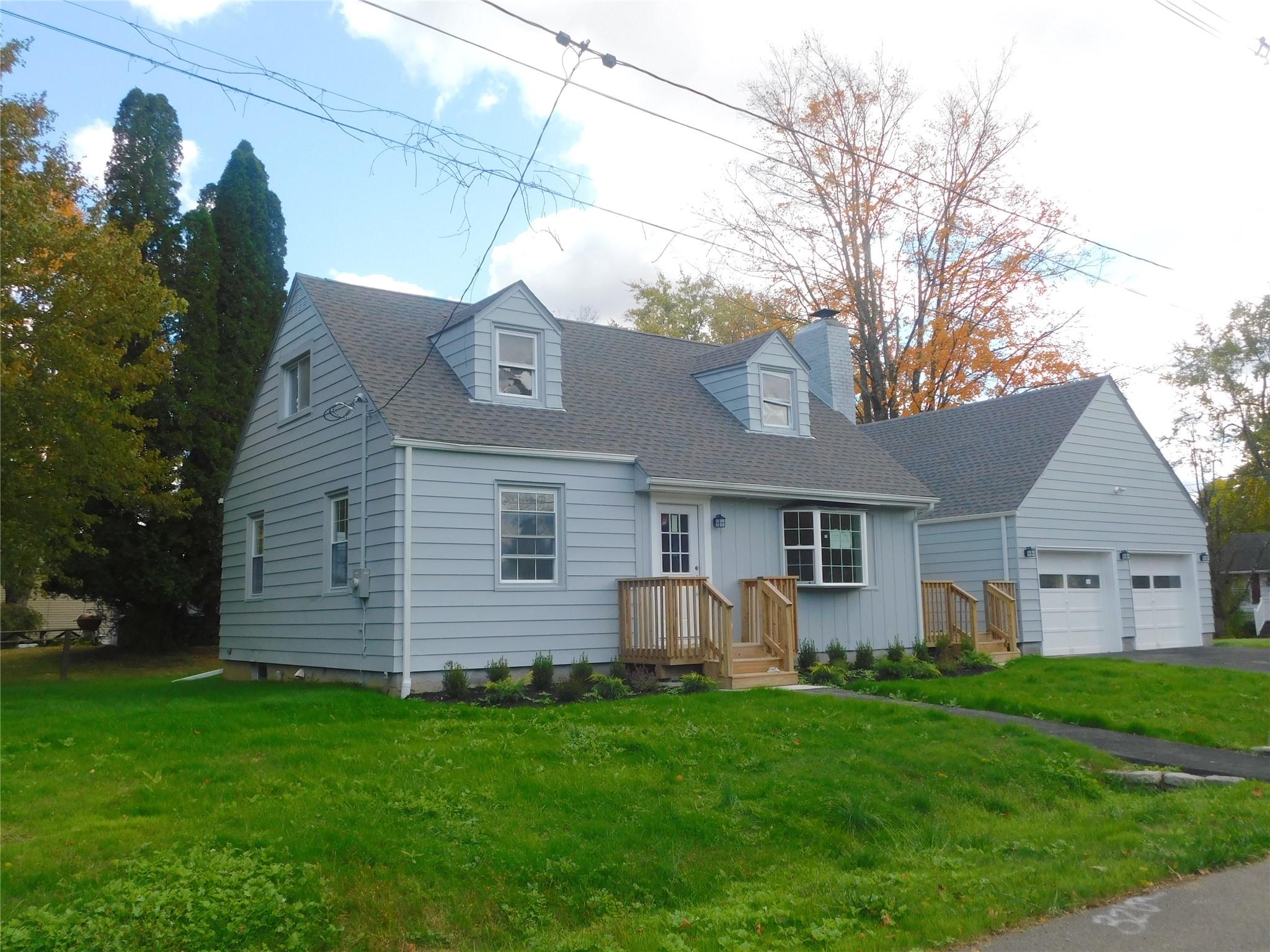 Cape cod house with a front lawn and a garage