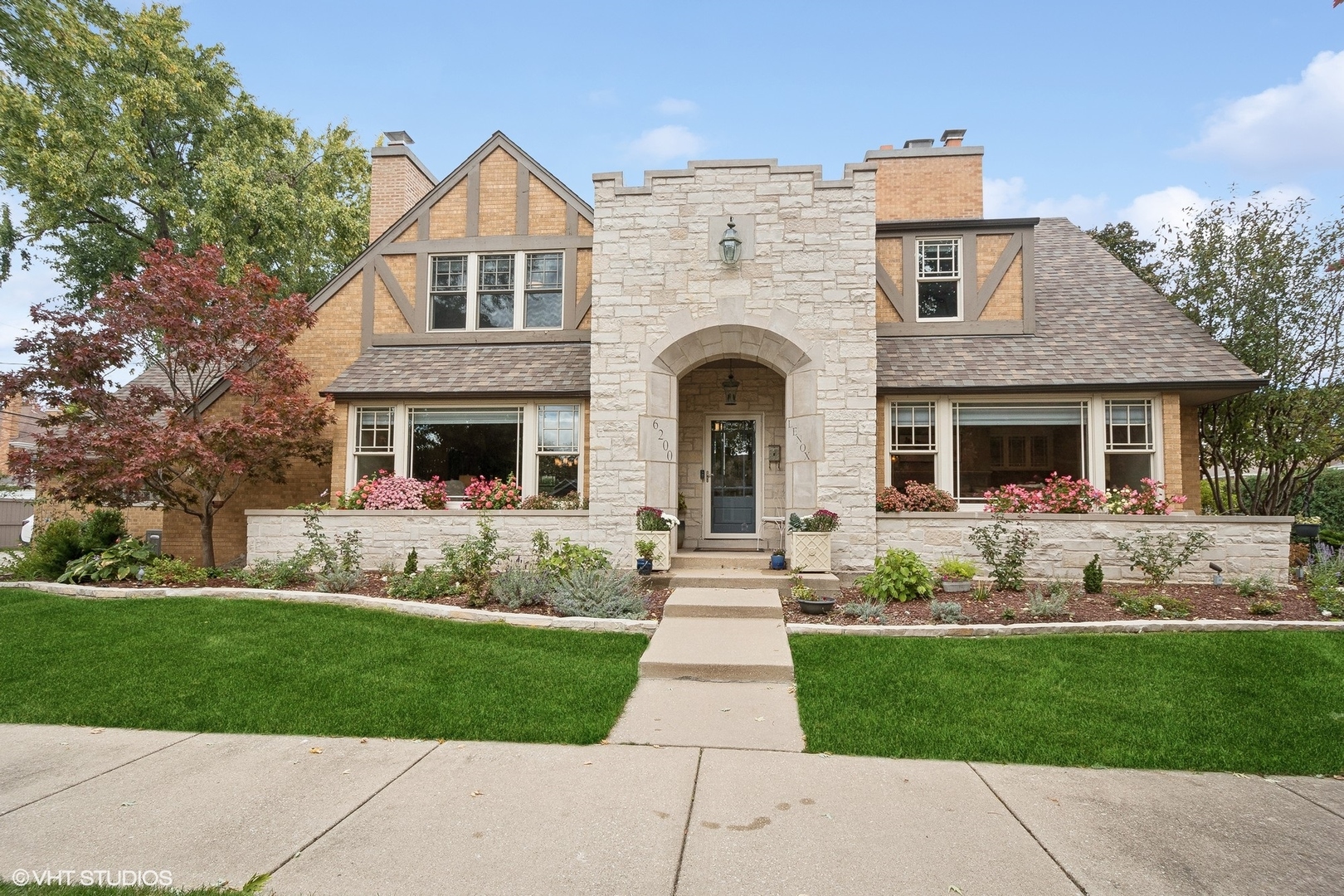 a front view of a house with a garden and plants