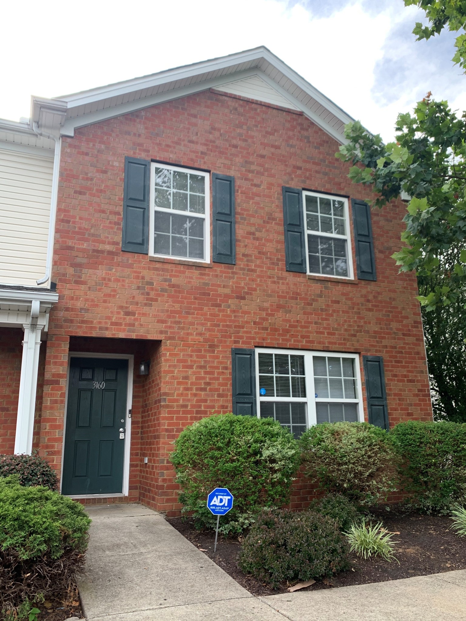 front view of brick house with a yard