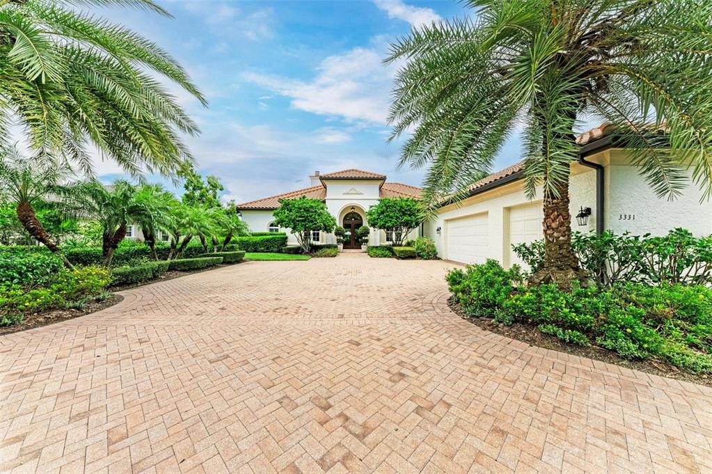 a front view of a house with a yard and potted plants