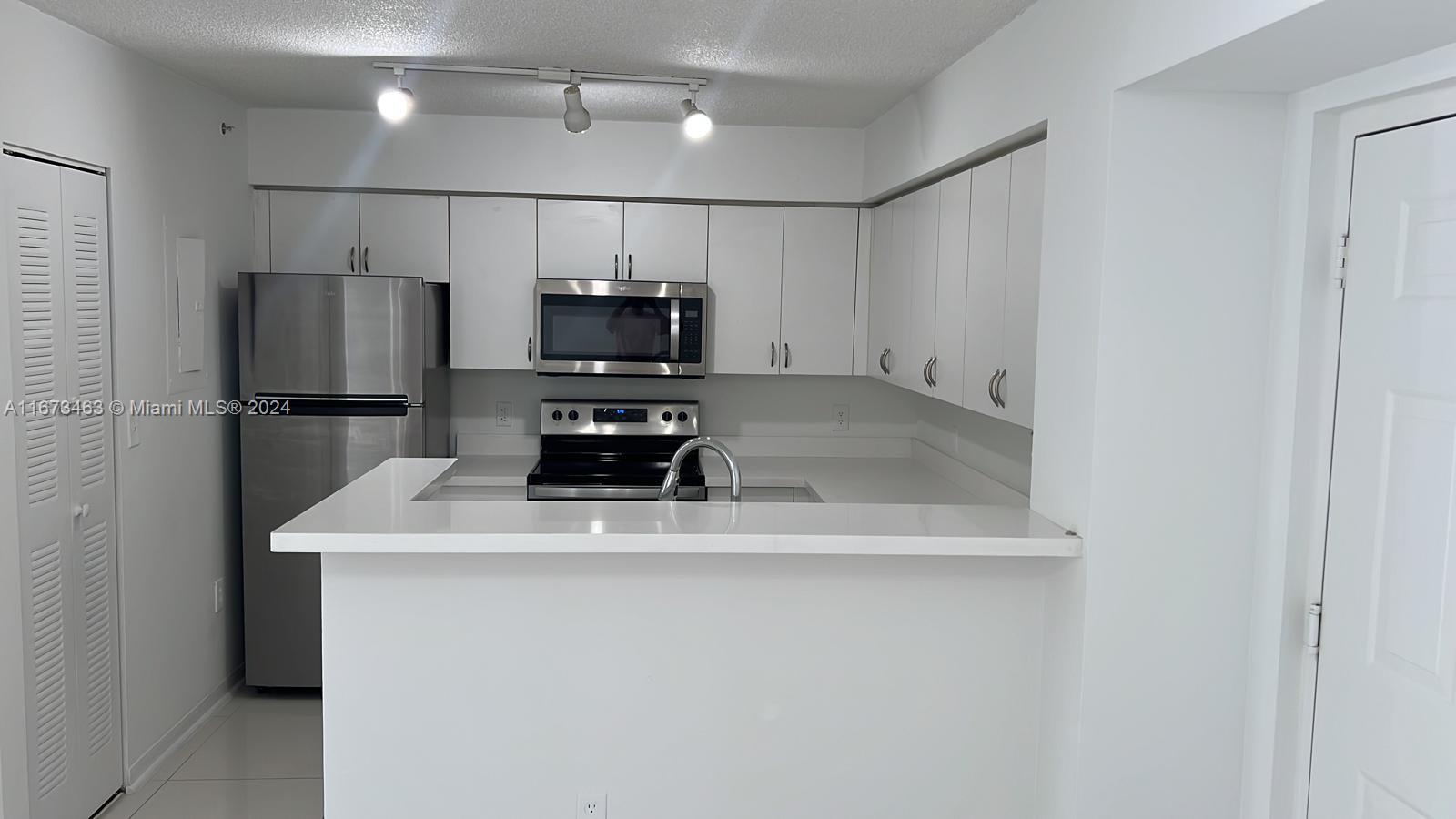 a kitchen with a refrigerator a microwave and sink