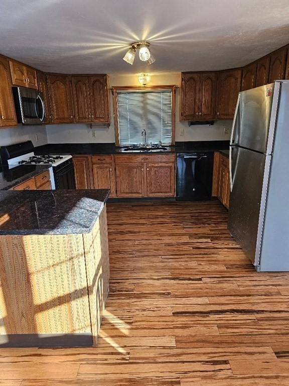 a kitchen with stainless steel appliances granite countertop a refrigerator and a stove