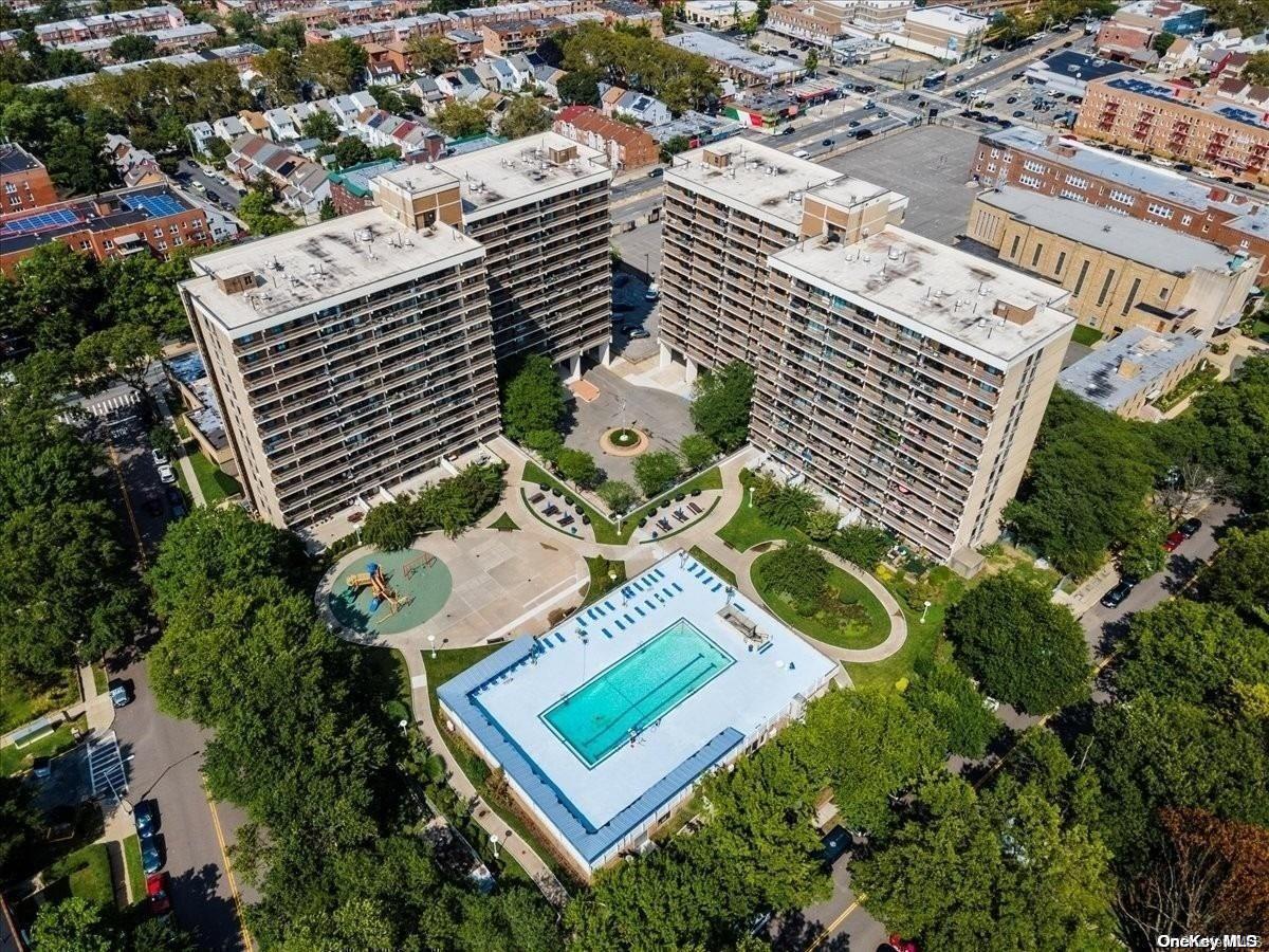 an aerial view of a residential apartment building with a yard and parking spaces