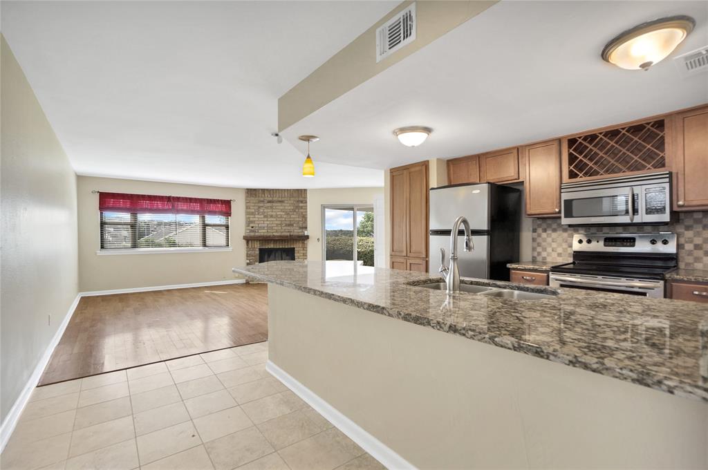 a large kitchen with stainless steel appliances granite countertop a stove and a sink