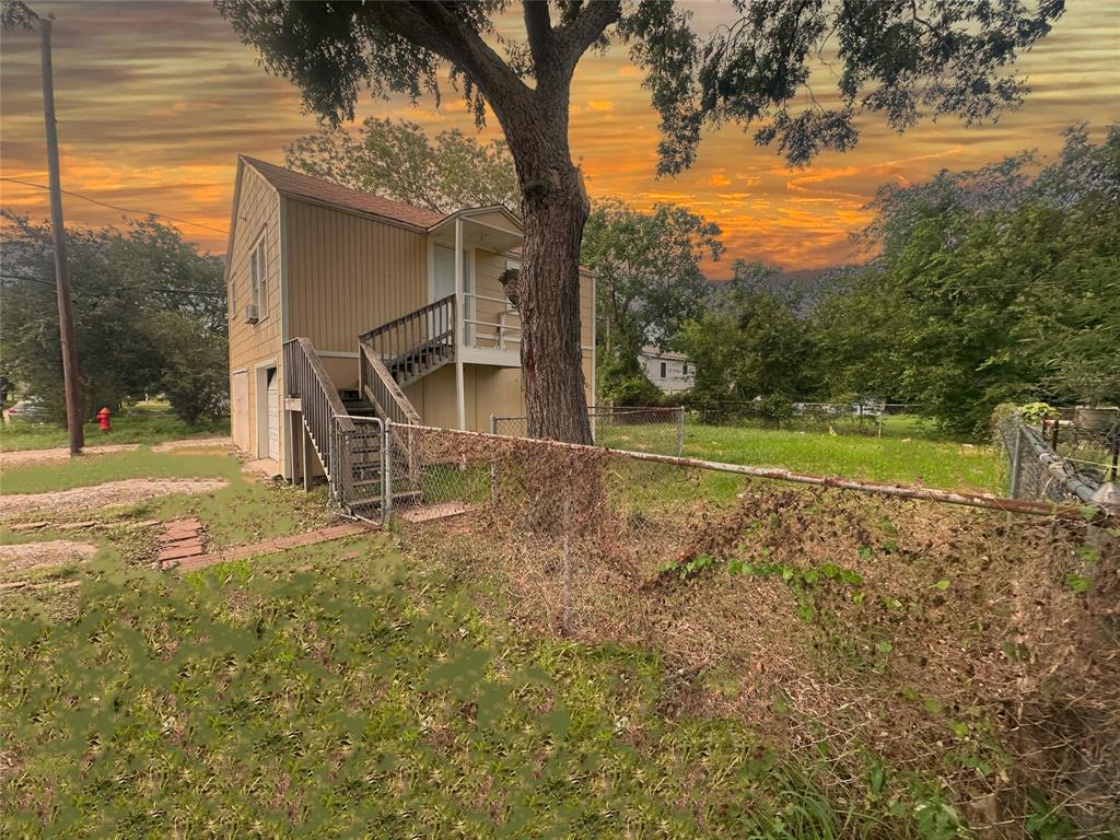 a view of a house with backyard and trees