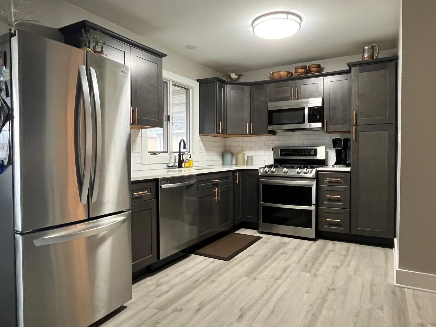 a kitchen with stainless steel appliances a refrigerator stove and microwave