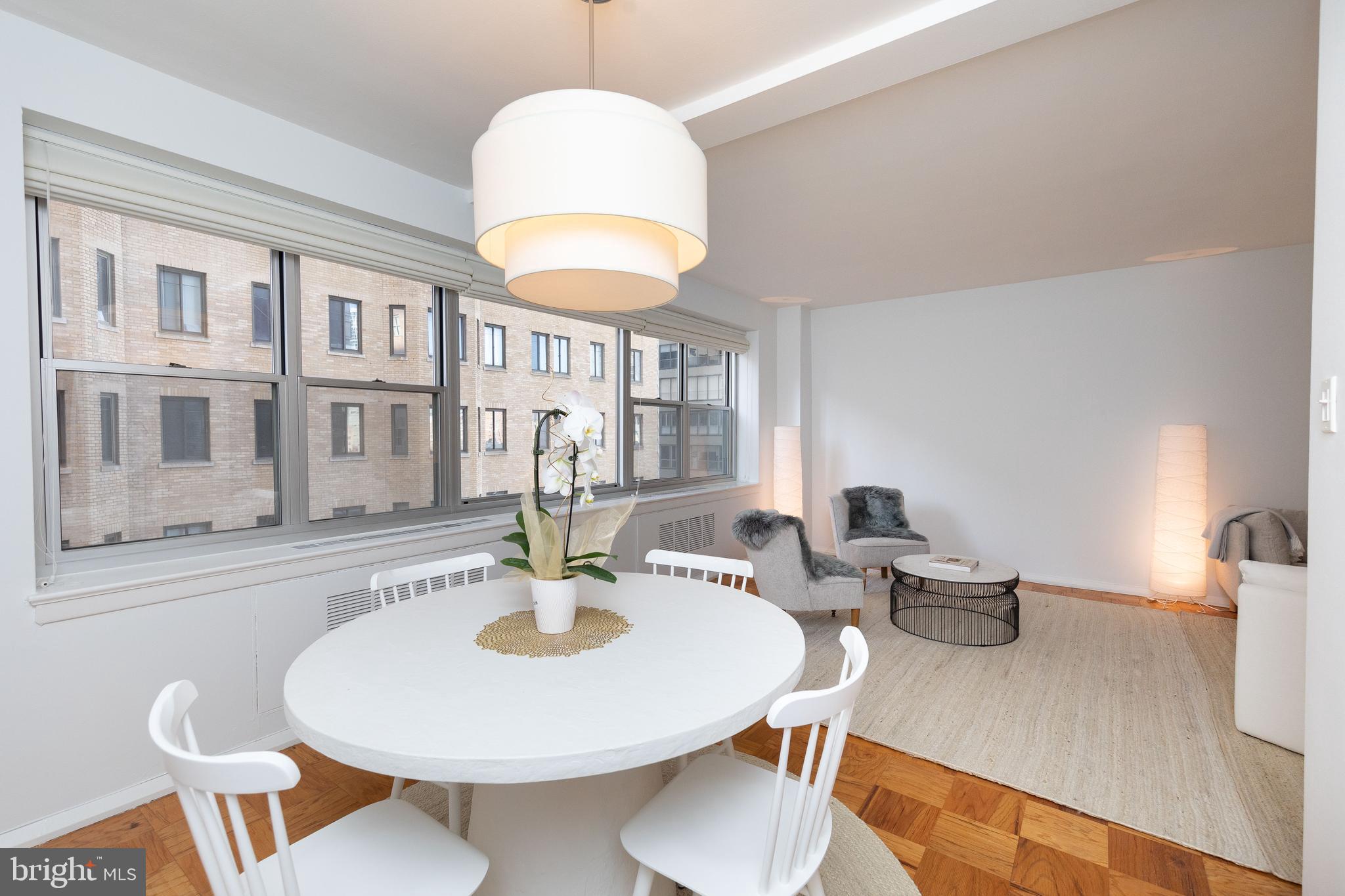 a view of a dining room with furniture a chandelier and wooden floor