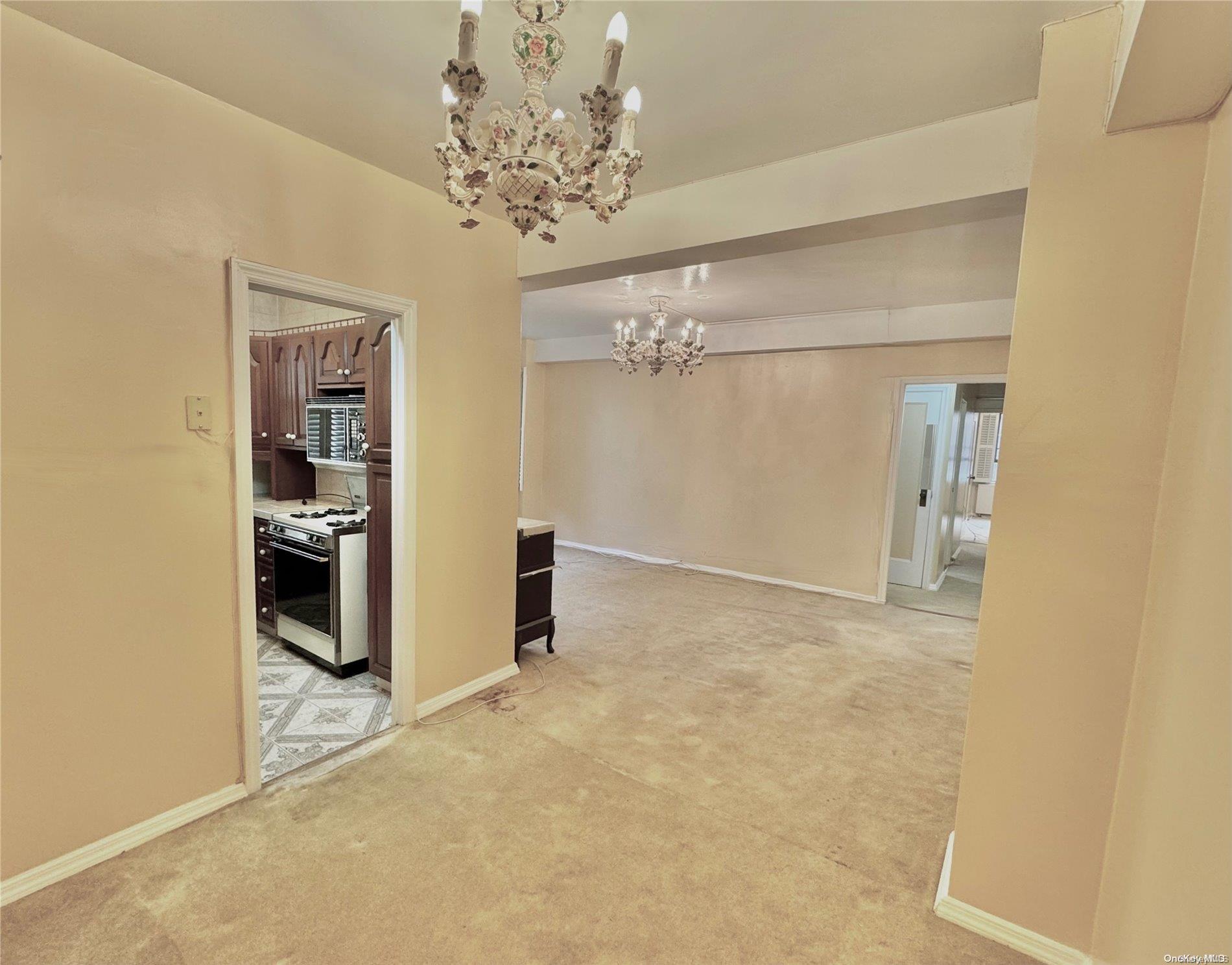 a view of a hallway with wooden floor and chandelier