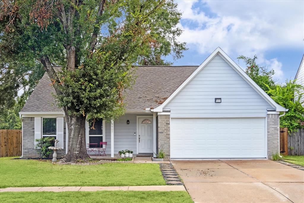 This one-story home features a charming blend of brick and wood, creating a warm and inviting exterior.