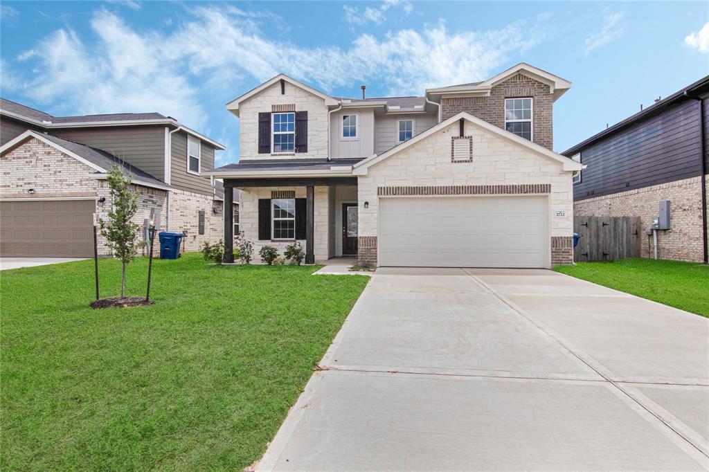 a front view of a house with a yard and garage