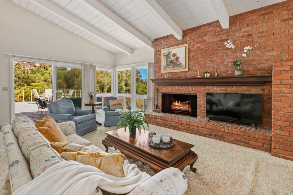 a living room with furniture a large window and a fireplace