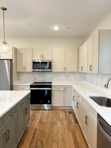 a kitchen with granite countertop a sink a stove and cabinets