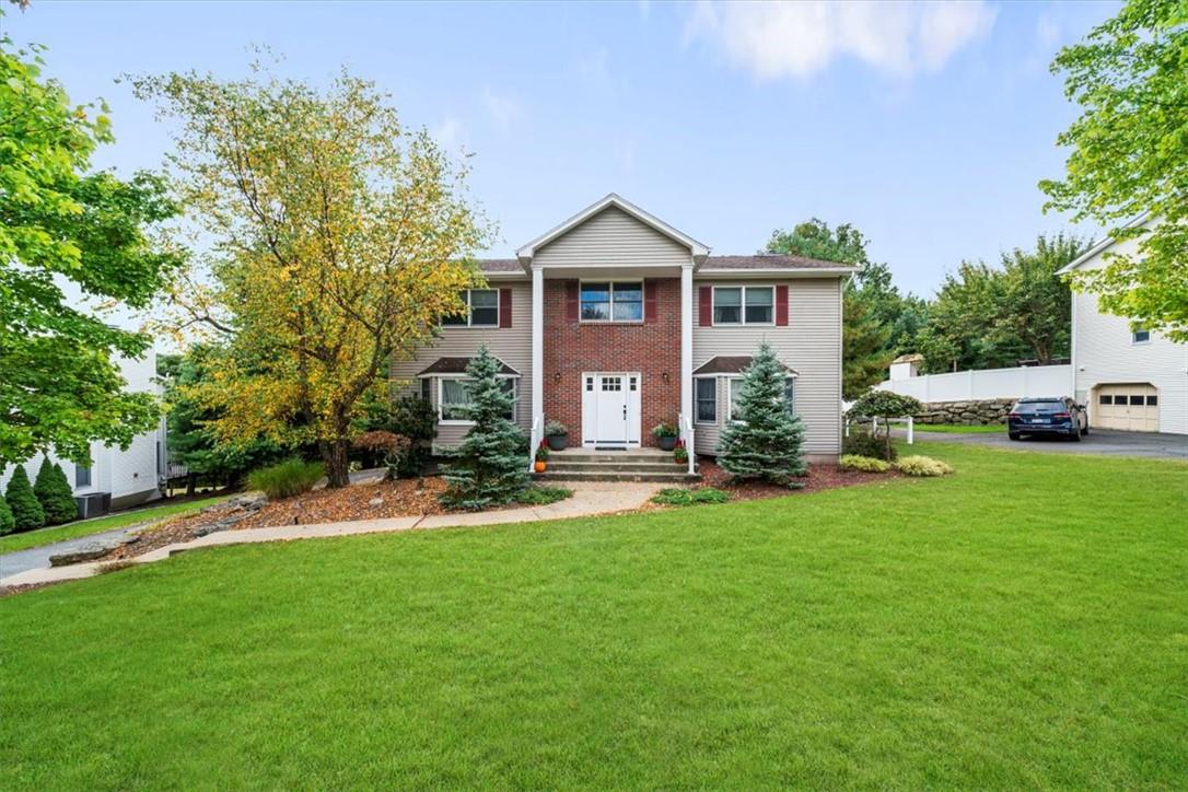 a front view of a house with a yard and trees