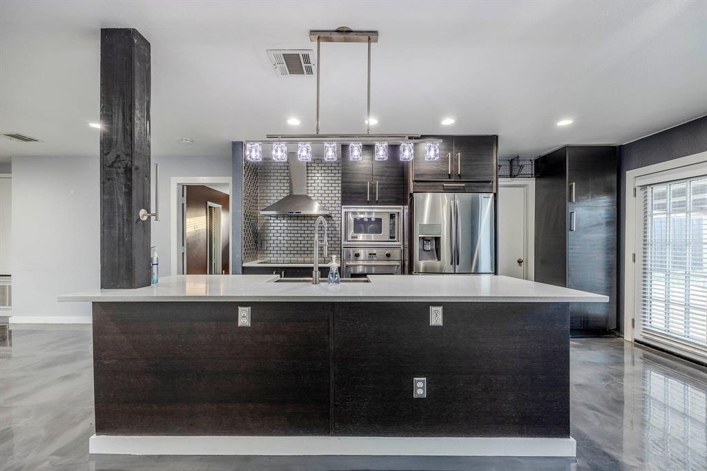 a large kitchen with stainless steel appliances a large counter top