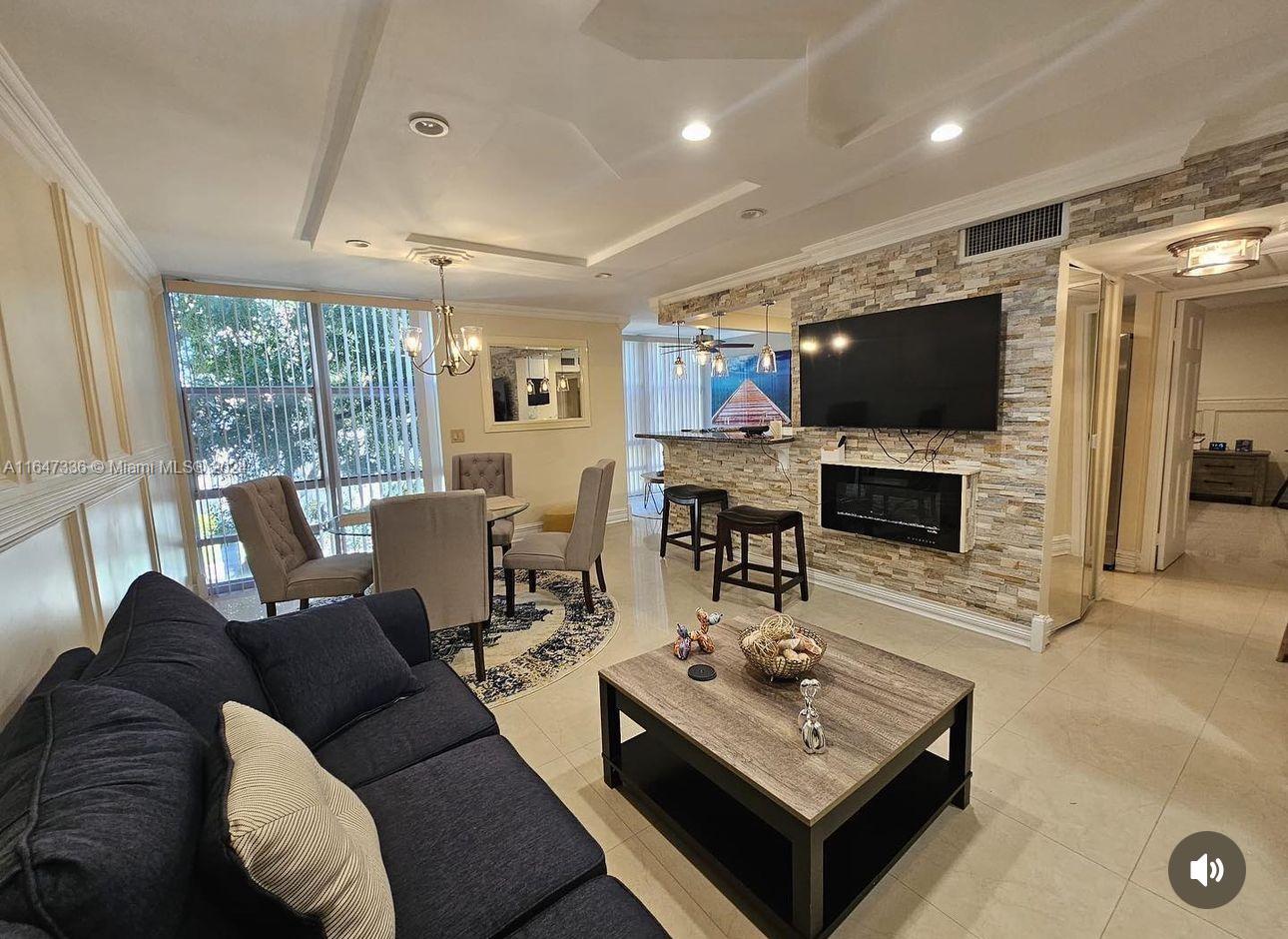 a living room with furniture a flat screen tv and a large window