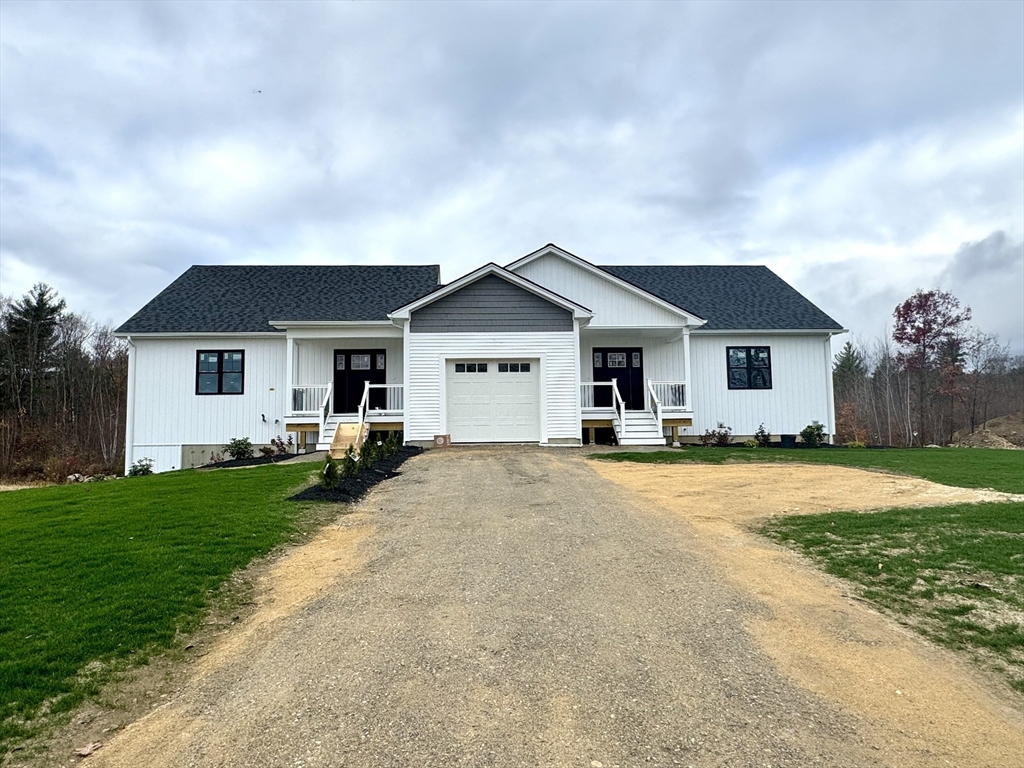 a front view of a house with yard and green space