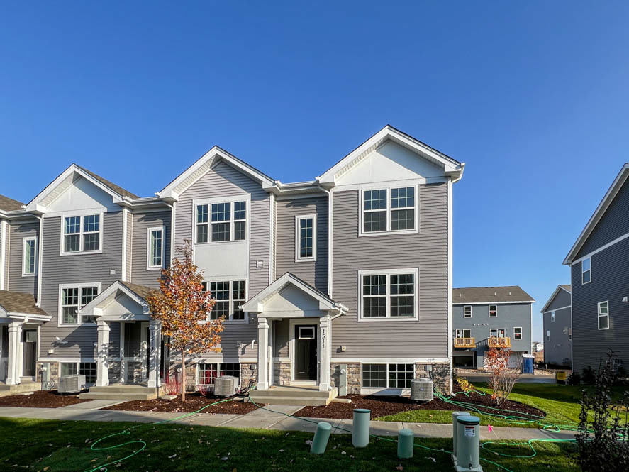 a front view of a residential houses with yard and green space