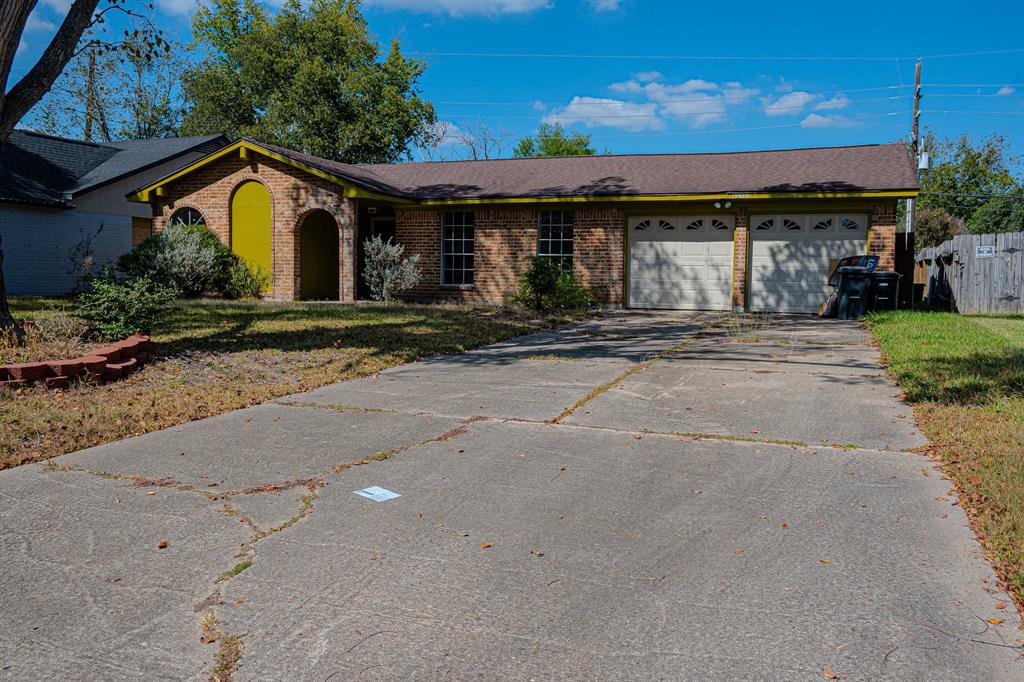 a view of a house with a yard and large tree