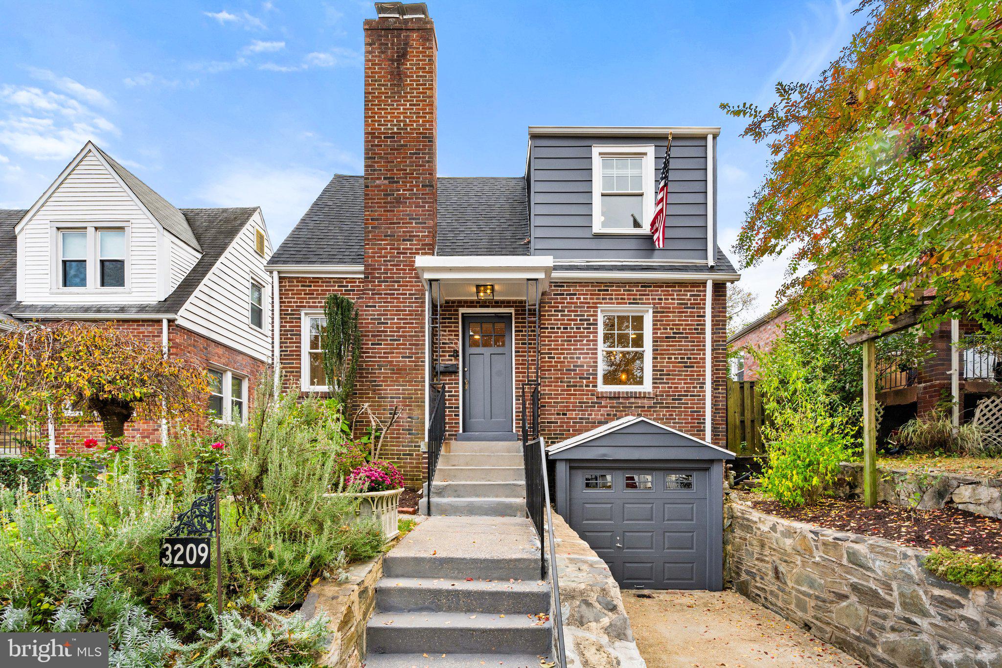 a front view of a house with a yard and potted plants