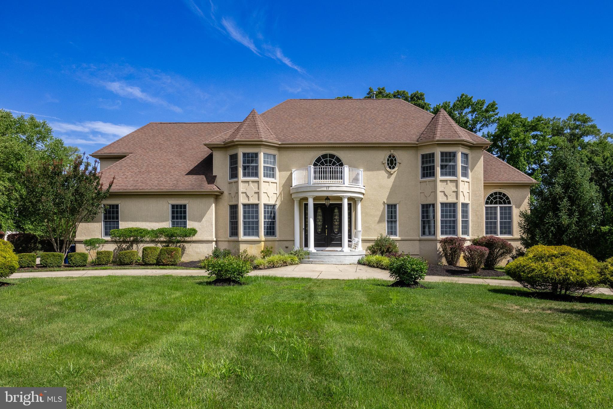 a front view of a house with a garden and trees