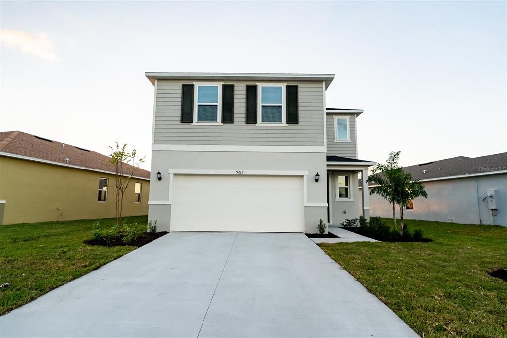 a front view of a house with a yard and garage