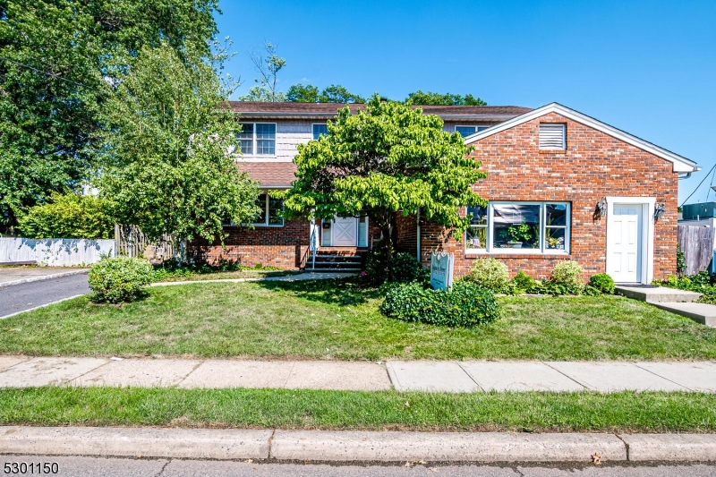 a front view of a house with a yard and potted plants