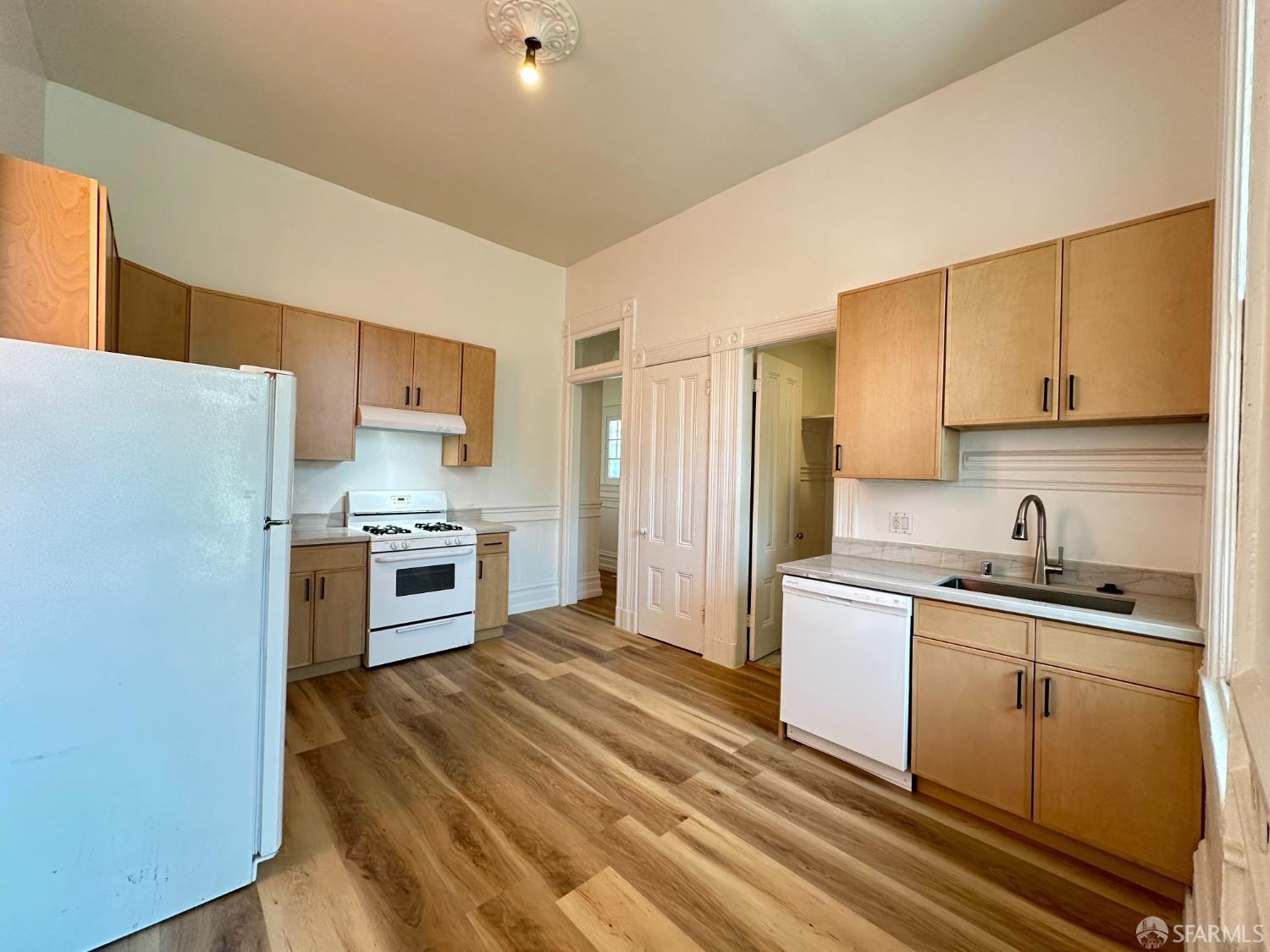 a kitchen with a sink a refrigerator and cabinets