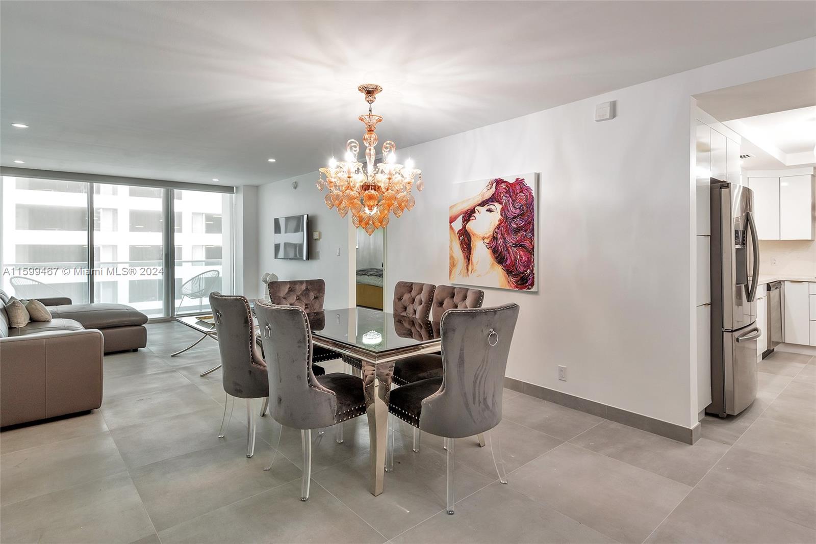 a view of a dining room with furniture a chandelier and large windows