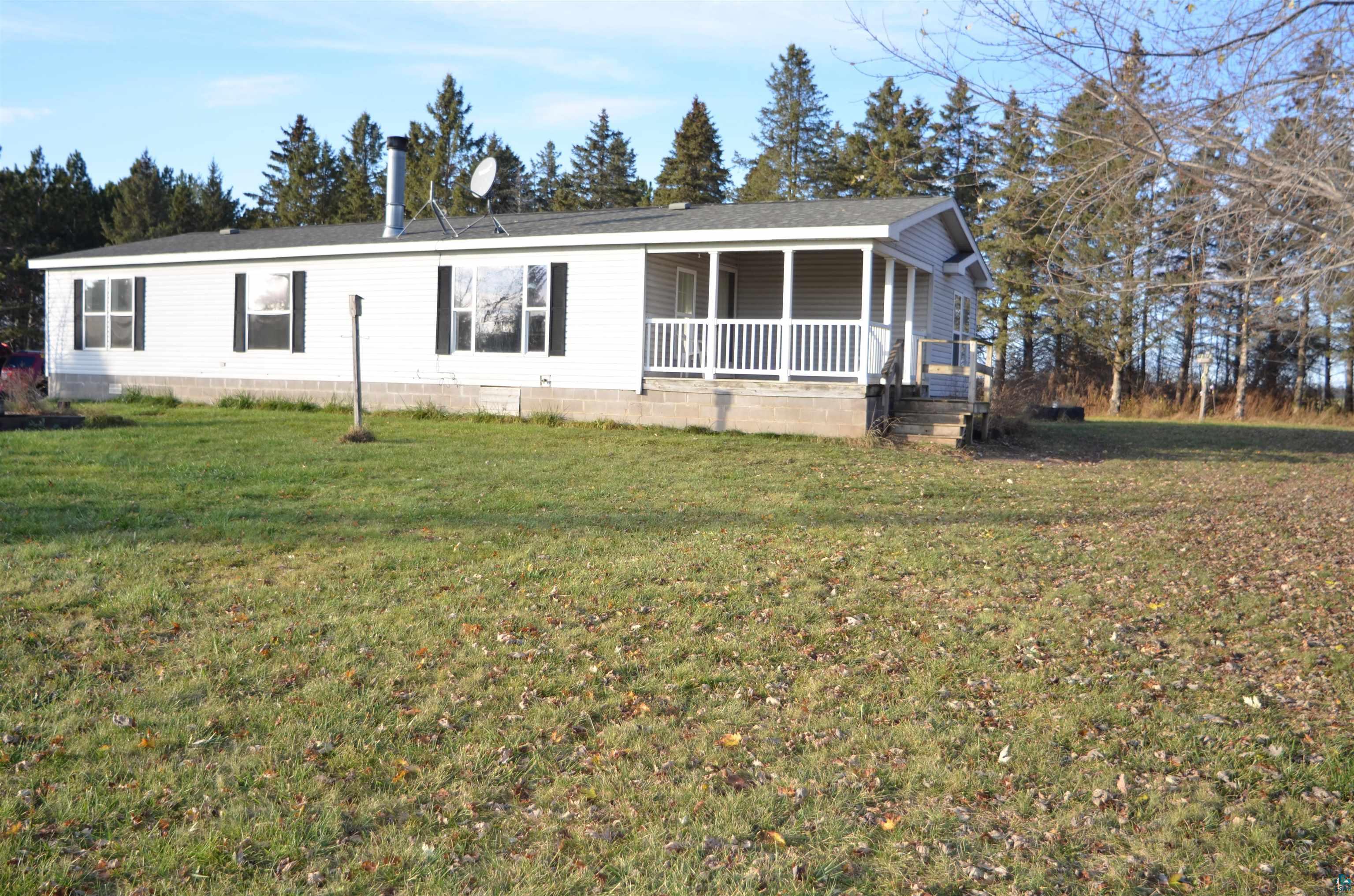 View of back of property featuring covered porch and yard