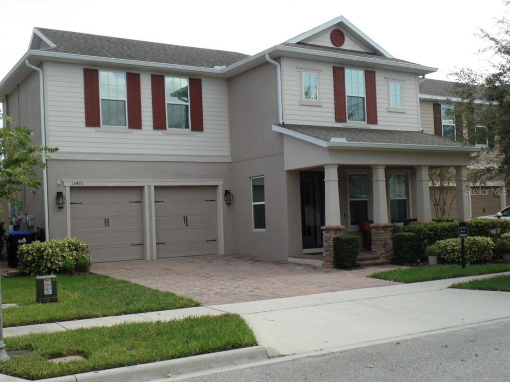 a front view of a house with a garden and garage