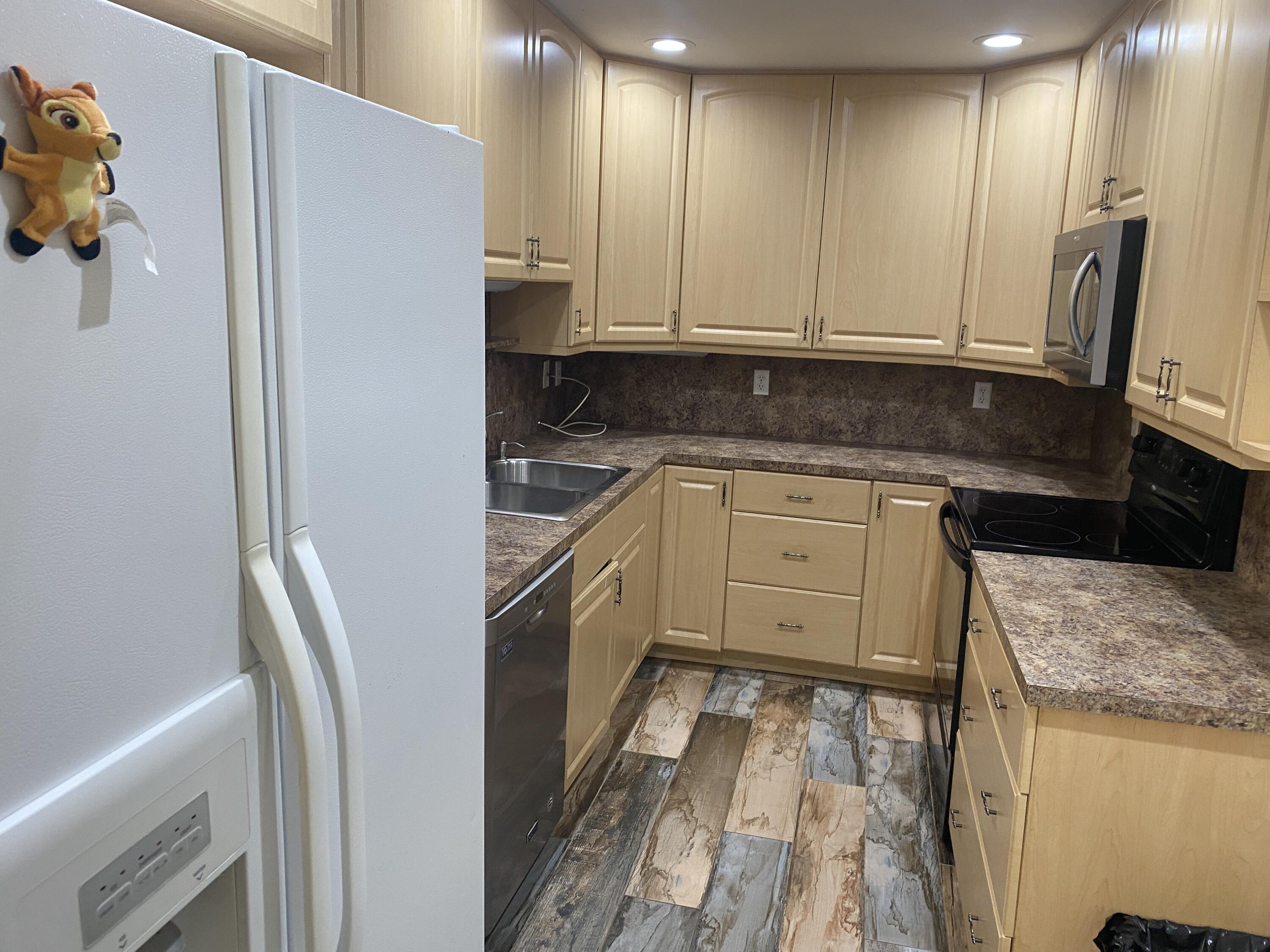 a kitchen with stainless steel appliances granite countertop a refrigerator and a stove top oven