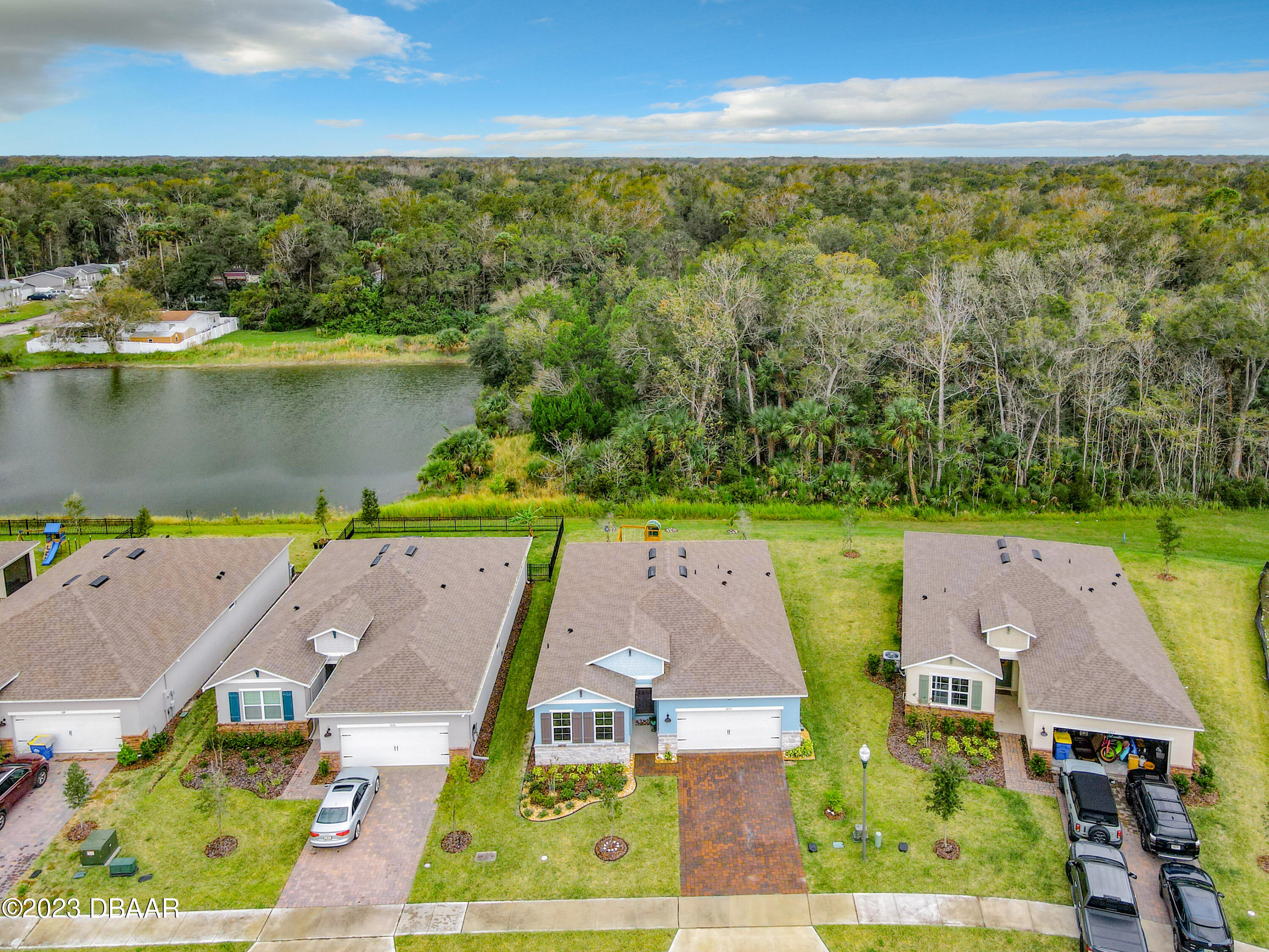 an aerial view of residential houses with outdoor space and lake view