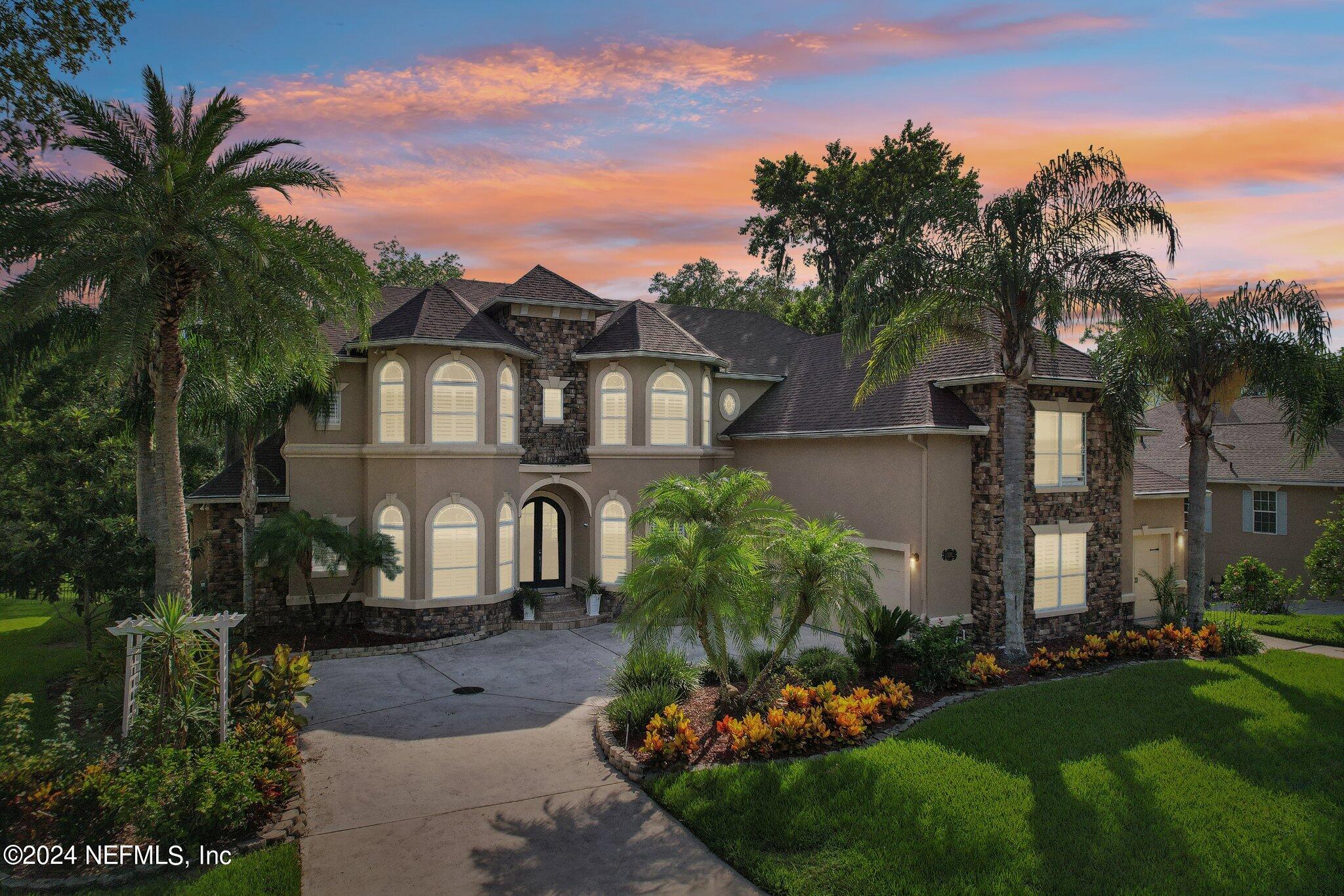 a front view of a house with a yard and potted plants