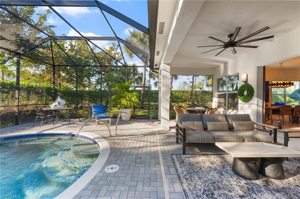 a living room with patio furniture and a floor to ceiling window