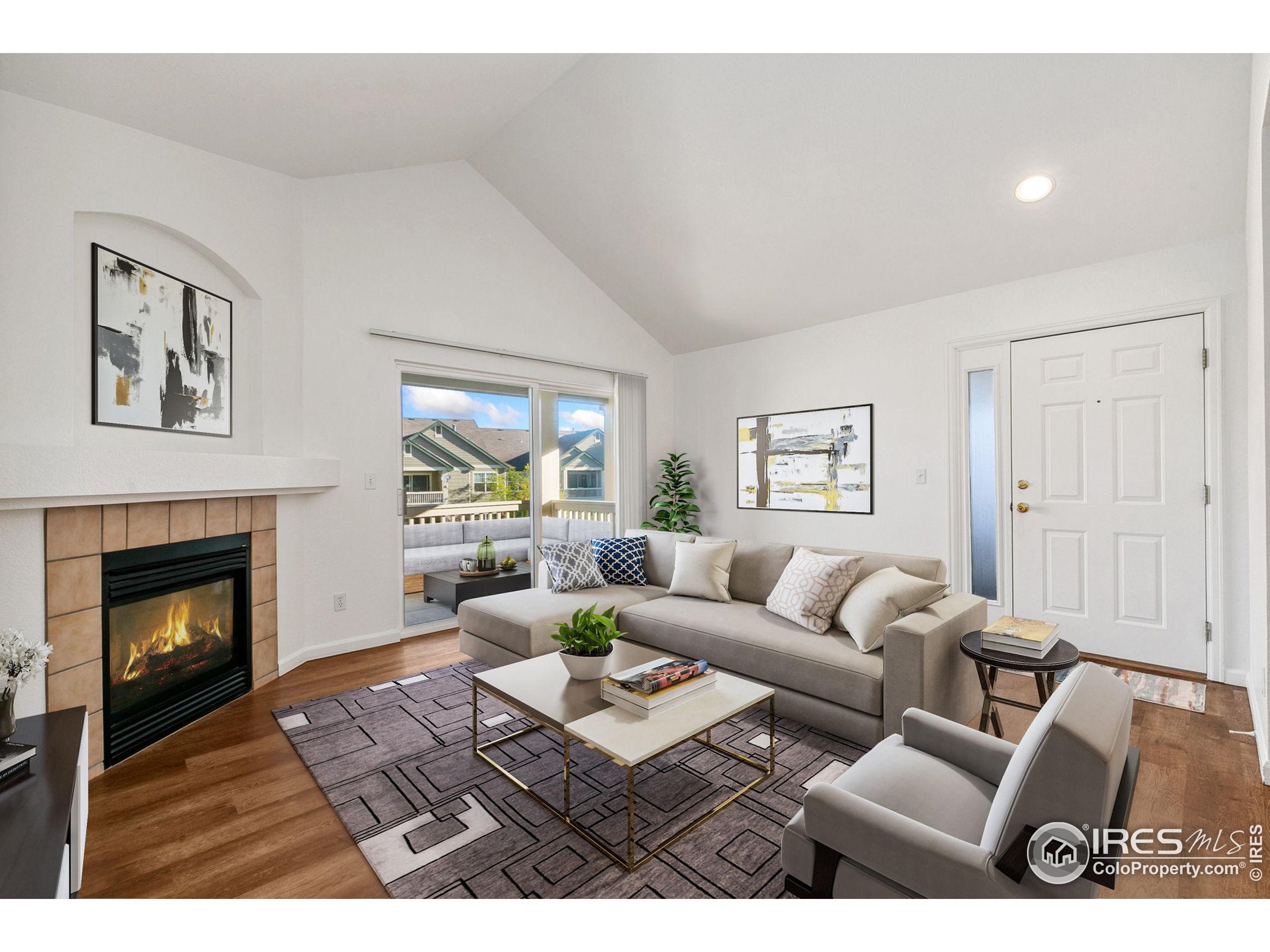 a living room with furniture a fireplace and a large window