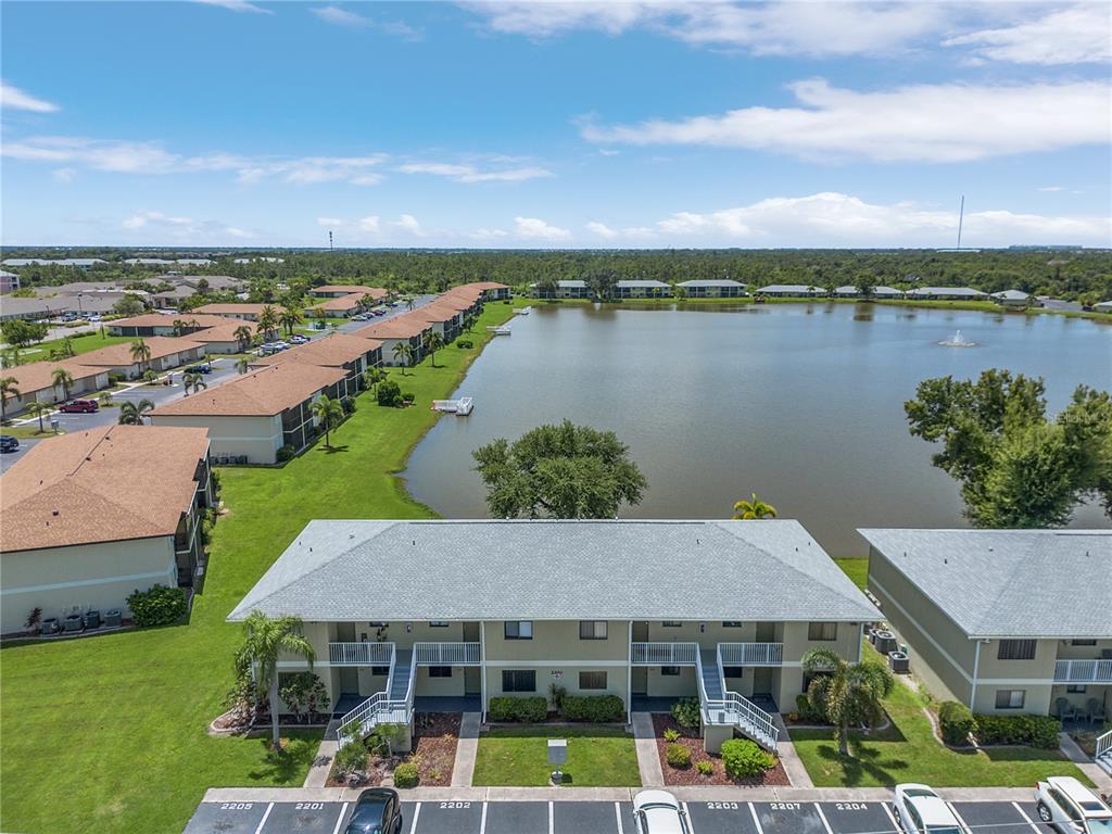 an aerial view of a house with outdoor space and lake view in back