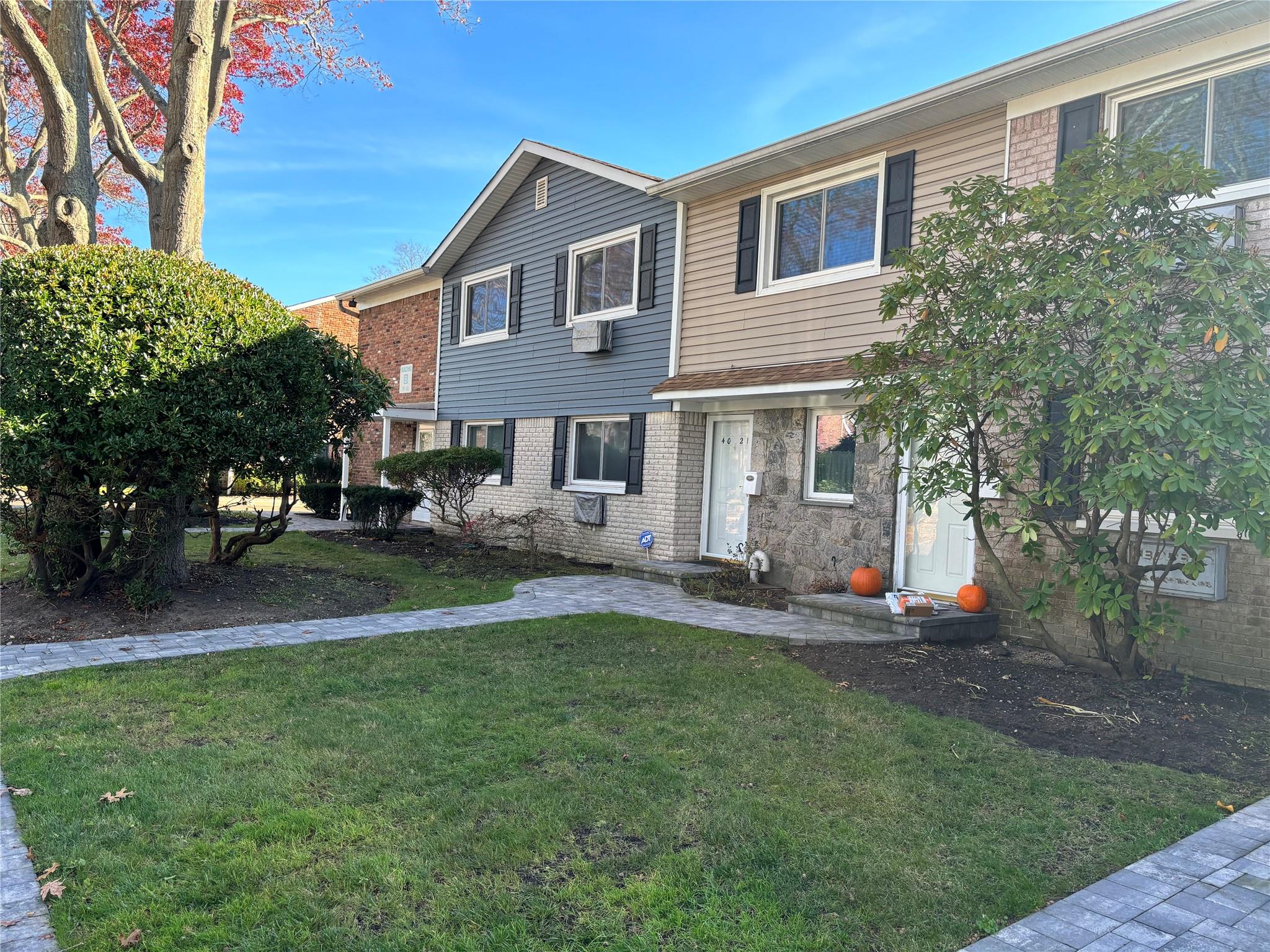 a front view of a house with a yard and trees