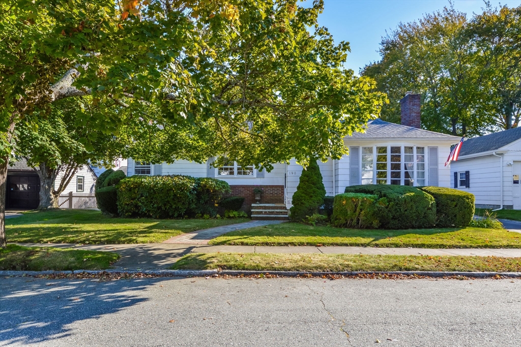 a view of a house with a big yard plants and large trees