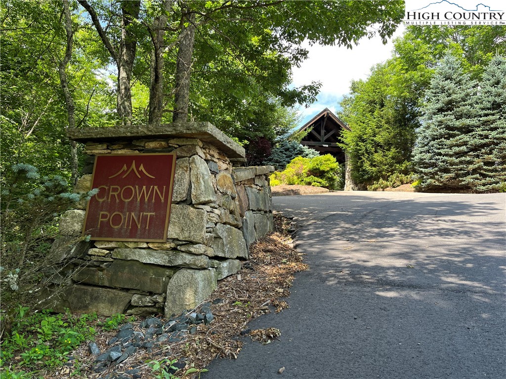 a sign board with tree in the background