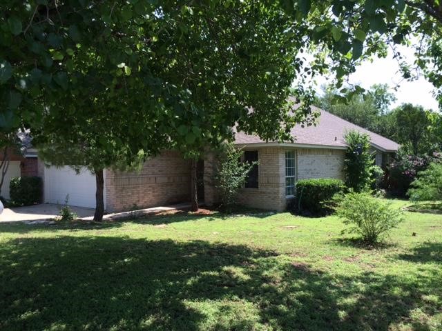 a front view of a house with a yard and tree