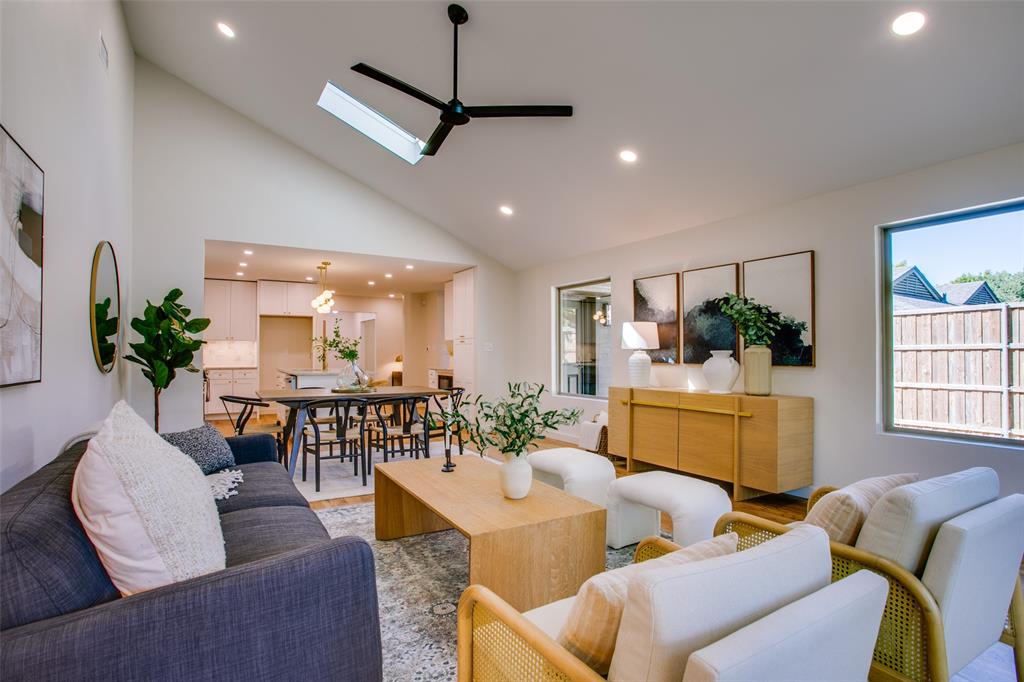 a living room with furniture kitchen view and a large window